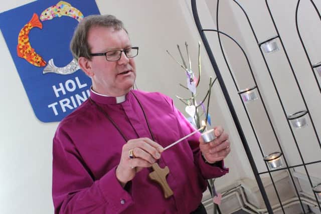 The Bishop of Portsmouth, the Rt Rev Christopher Foster lights a candle as he spends time in prayer at Holy Trinity Church, Fareham, for the victims of the Westminster attack.