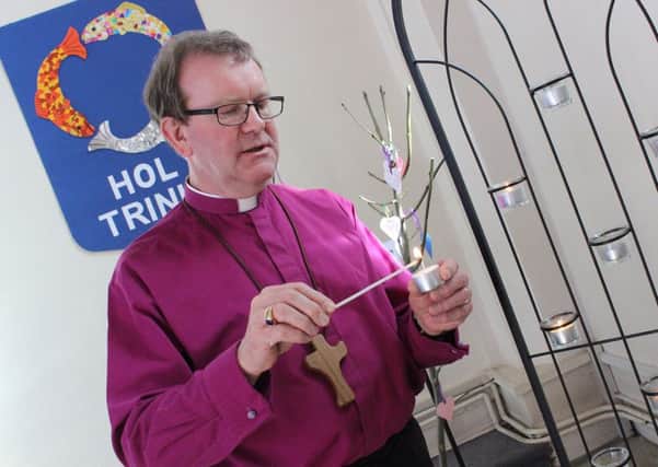 The Bishop of Portsmouth, the Rt Rev Christopher Foster lights a candle as he spends time in prayer at Holy Trinity Church, Fareham, for the victims of the Westminster attack.