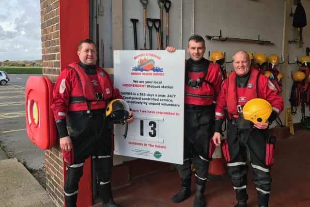 Gafirs senior coxswain Brian Pack, left, and crewmen James Baggott, centre, and Paul Goulder  with the new status board from Top Notch Signs