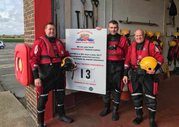 Gafirs senior coxswain Brian Pack, left, and crewmen James Baggott, centre, and Paul Goulder  with the new status board from Top Notch Signs