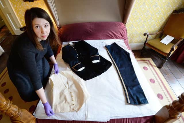 Curator of the Charles Dickens Museum Frankie Kubicki with a woollen court suit that was worn by Charles Dickens in 1870 Picture: John Stillwell/PA Wire