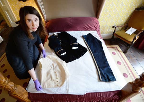Curator of the Charles Dickens Museum Frankie Kubicki with a woollen court suit that was worn by Charles Dickens in 1870 Picture: John Stillwell/PA Wire