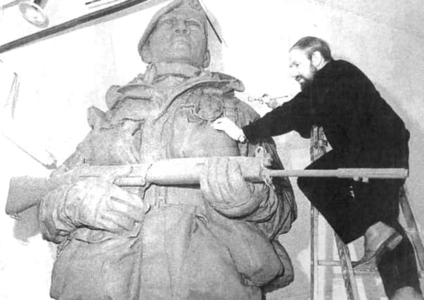 Philip Jackson applies the finishing touches to the towering clay model (9221-1)