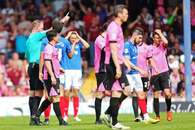 Mark Brown shows Kieron Freeman a red card during Pompey's game with Northampton at the end of last season