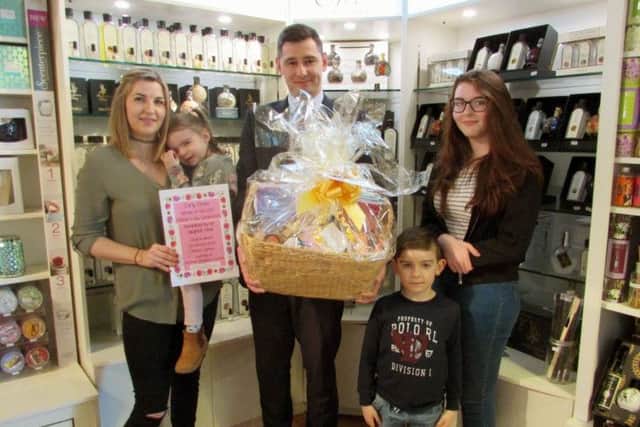 Mum Carly Drew, left, with her children and Fareham Shopping Centre deputy manager Jakub Chrus, holding the pamper hamper