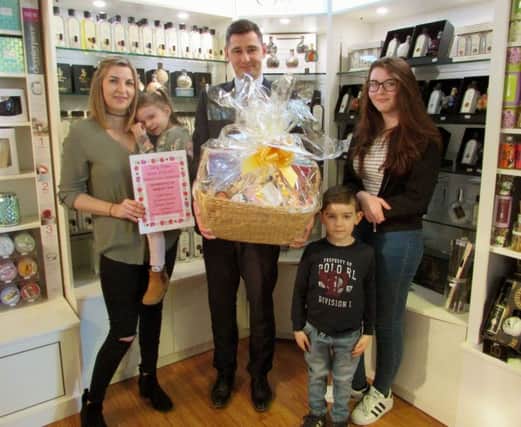 Mum Carly Drew, left, with her children and Fareham Shopping Centre deputy manager Jakub Chrus, holding the pamper hamper