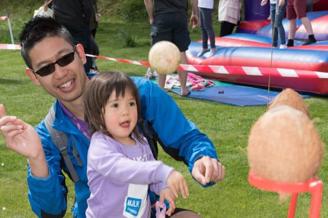 Azumi Chan, two, and her dad Tim try to win a coconut Picture: Keith Woodland (170440-023)
