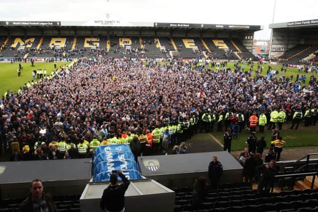 Pompey fans celebrate on the pitch at Meadow Lane after beating Notts County to seal promotion Picture: Joe Pepler