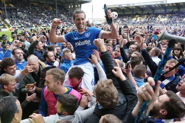 Christian Burgess is held aloft by Pompey pitch invaders. Picture: Joe Pepler