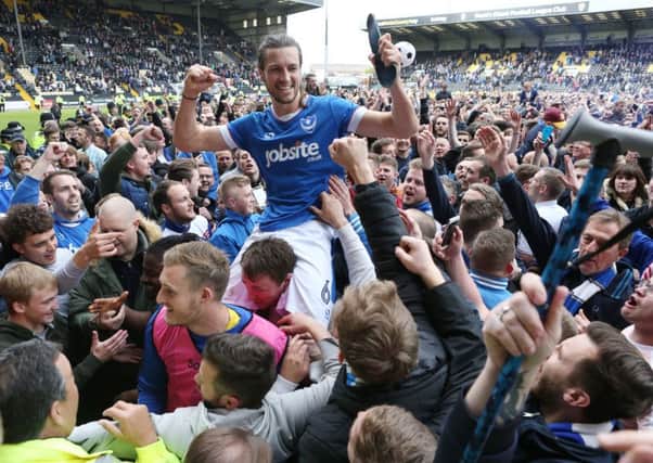 Christian Burgess is held aloft by Pompey pitch invaders. Picture: Joe Pepler