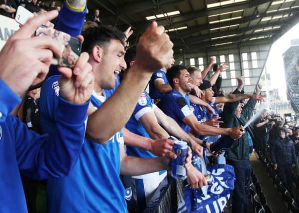 The Pompey players celebrate promotion from the boardroom balcony at Meadow Lane following Mondays 3-1 win against Notts County Picture: Joe Pepler