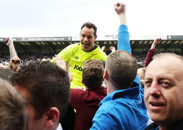Pompey keeper David Forde is held aloft by Pompey fans on the pitch at Meadow Lane