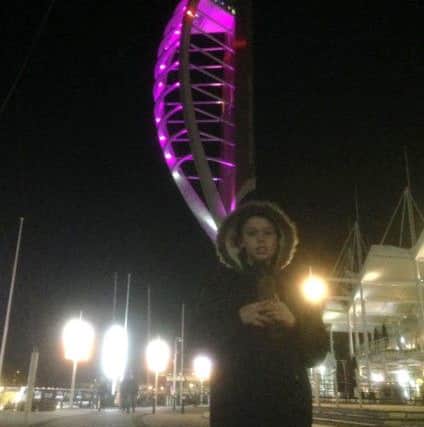 The winning picture of Matthew holding his teddy in front of the Spinnaker when it was lit up purple of epilepsy awareness