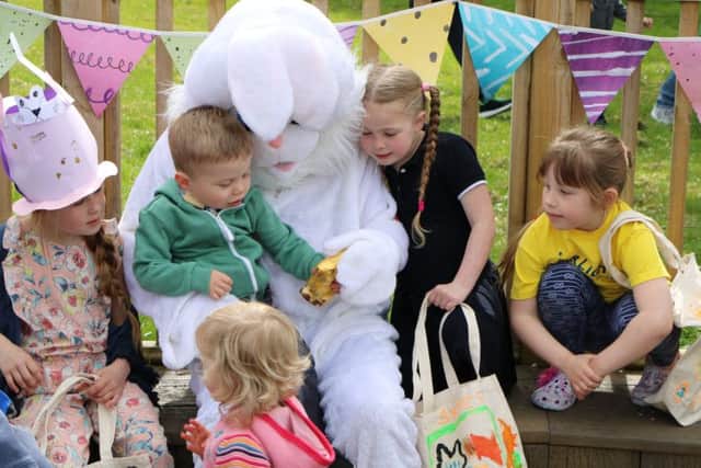 Children meet the Easter bunny that arrived by helicopter