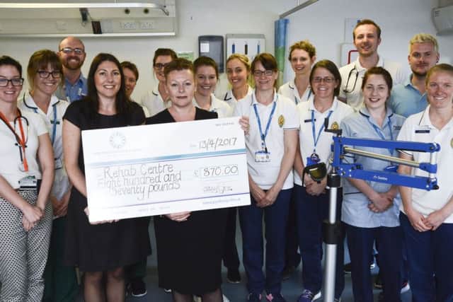 Staff from John Lewis in Southsea hand over a cheque to the physiotherapists at Queen Alexandra Hospital, in Cosham