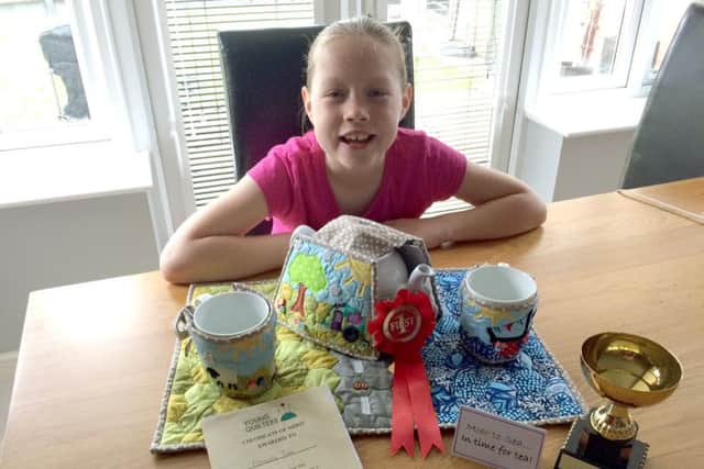 Matilda Tate with her winning entry to the quilting awards, a quilted tea set