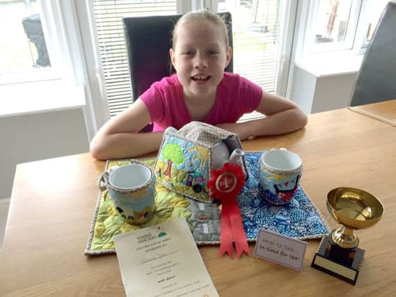 Matilda Tate with her winning entry to the quilting awards, a quilted tea set