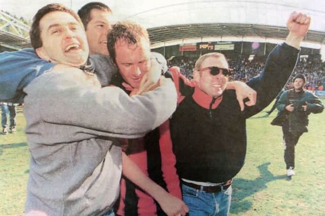 Guy Butters is mobbed by joyful fans as the final whistle secured Pompeys place in the first division for next season