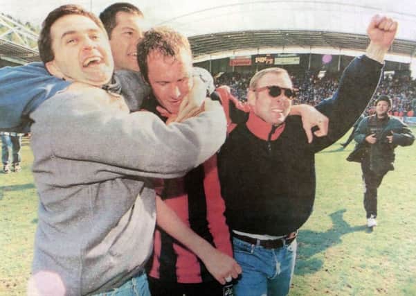 Guy Butters is mobbed by joyful fans as the final whistle secured Pompeys place in the first division for next season
