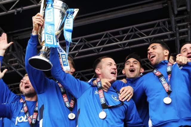 Michael Doyle lifts the League Two trophy. Picture: Joe Pepler