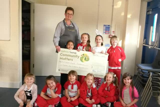 Alice Lawrie, the Community Matters champion for Waitrose, Southsea, presenting a cheque to the 2nd Portsmouth Rainbows