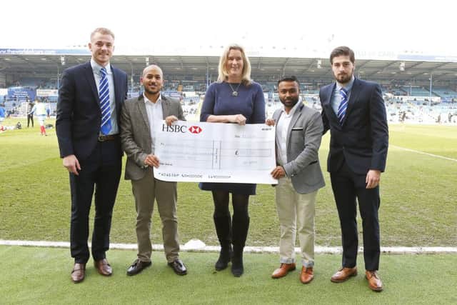 Faz Ahmed and Jaf Ahmed, from Akash, presenting a cheque to Pompeys Jack Whatmough and Kieron Freeman, and Clare Martin from Pompey in the Community.