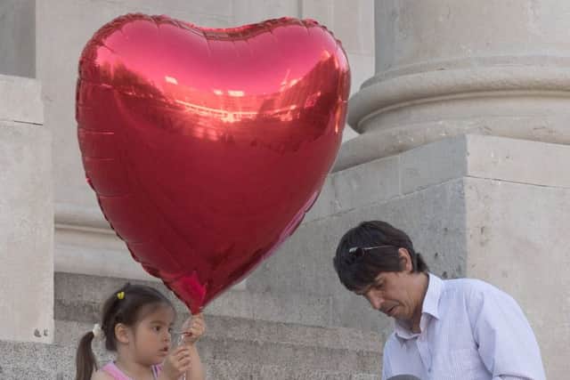 A little girl prepares to release a heart-shaped balloon during a vigil for the victims of the Manchester bombing on the steps of Portsmouth Guildhall. Picture Keith Woodland (170679-005)