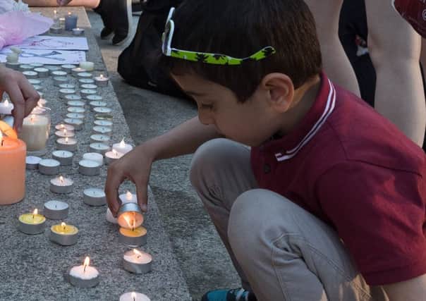 Worth Ibrahim, five, lights candles at a vigil for victims of the Manchester bombing, held at Portsmouth Guildhall