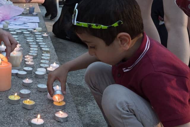 Worth Ibrahim, five, lights candles at a vigil for victims of the Manchester bombing, held at Portsmouth Guildhall