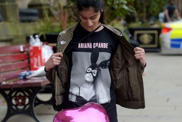 Iqra Saied, 13, wears an Ariana Grande t-shirt as she looks at flowers outside Manchester Town Hall