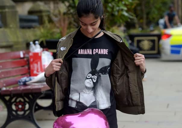 Iqra Saied, 13, wears an Ariana Grande t-shirt as she looks at flowers outside Manchester Town Hall