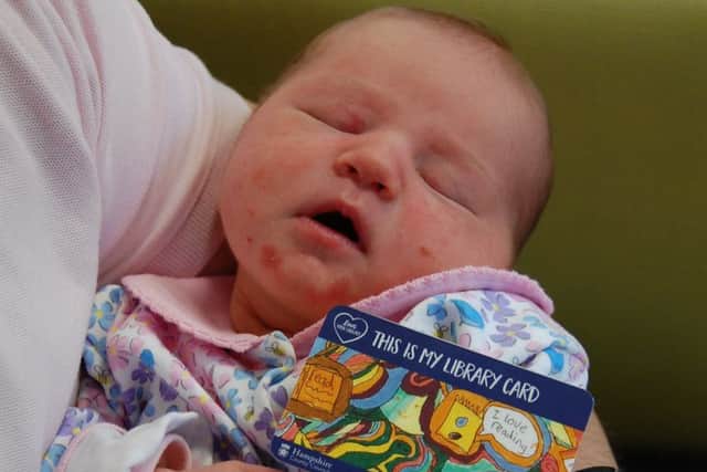 Three-day-old Jennifer Baker holding her new library card. Picture: Hampshire County Council