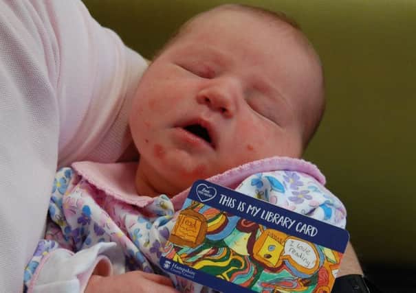 Three-day-old Jennifer Baker holding her new library card. Picture: Hampshire County Council