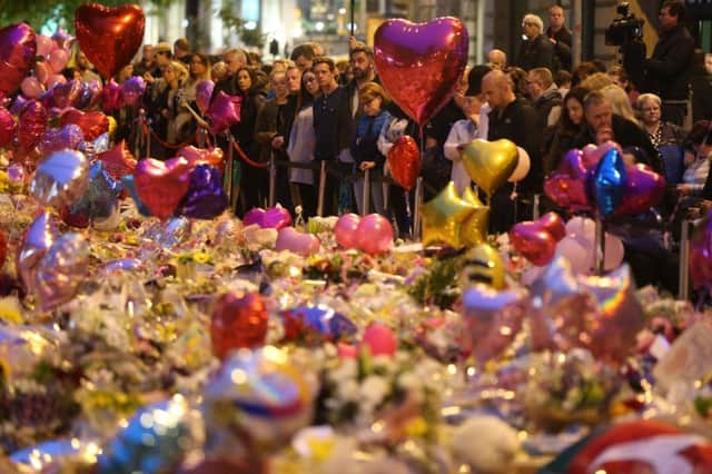 Wreaths and balloons in Manchester, above, and Rev Sean, below. 	                                   Picture by Jonathan Brad/PA