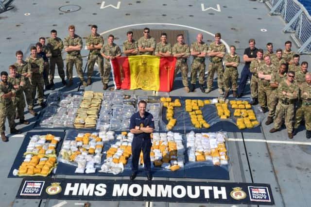 Royal Navy and Royal Marines Boarding team, with Cdr Ian Feasey, Commanding Officer, HMS Monmouth (centre) and the recovered drugs haul.