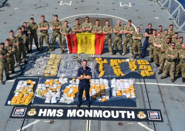 Royal Navy and Royal Marines Boarding team, with Cdr Ian Feasey, Commanding Officer, HMS Monmouth (centre) and the recovered drugs haul.