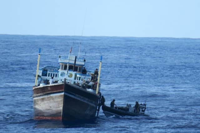 A Royal Navy boarding team from HMS Monmouth climbing on board to conduct a search of a fishing dhow which eventually yielded a drugs haul of 455kg of cannabis and 266kg of heroin.