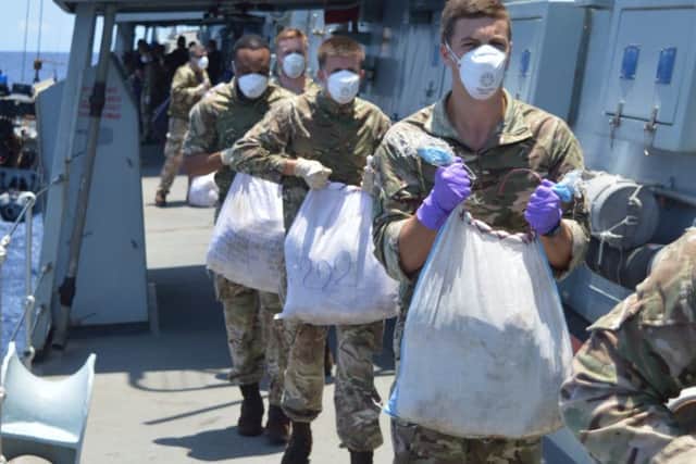 The Ship's Company of HMS Monmouth recovering the seized illicit drugs for accounting on board the Frigate before destruction.