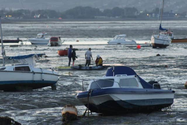 A RNLI crewman helps the stranded kayakers. Picture: Gene Davidson