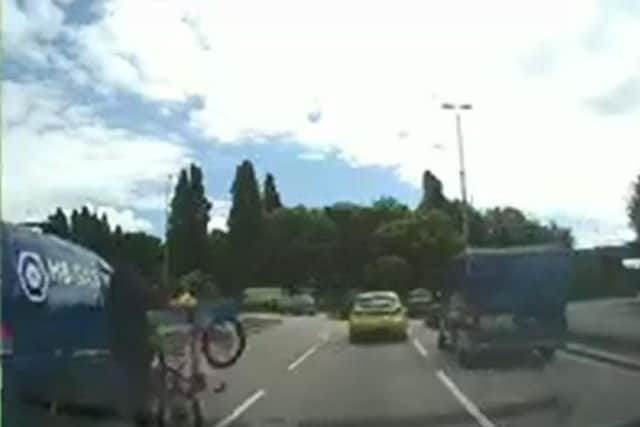 The cyclist is struck a glancing blow by the van