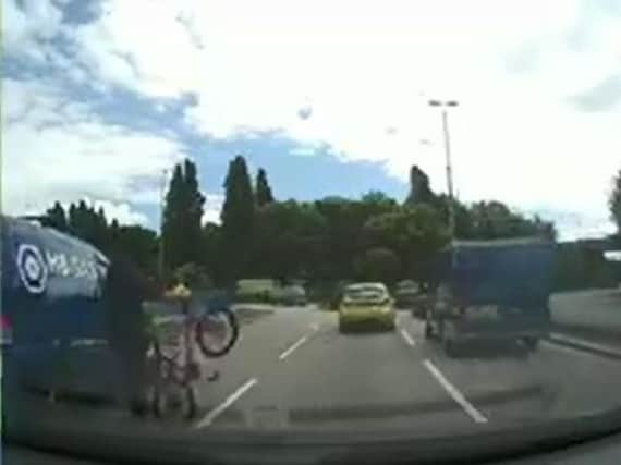 The cyclist is struck a glancing blow by the van
