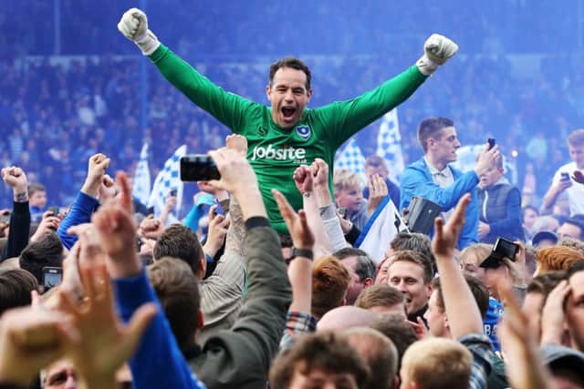 David Forde is hoisted loft the heads of Pompey fans who made their way on to the pitch at Fratton Park after the League Two title was won Picture: Joe Pepler