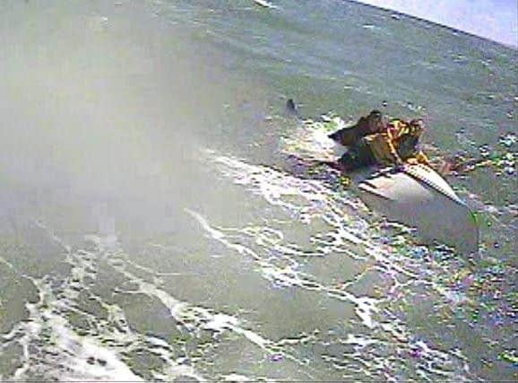 Two casualties cling to an upturned dinghy. Picture: RNLI/Brittany Jones