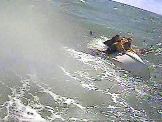Two casualties cling to an upturned dinghy. Picture: RNLI/Brittany Jones