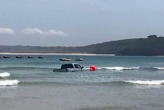 The tide sweeps around the car
