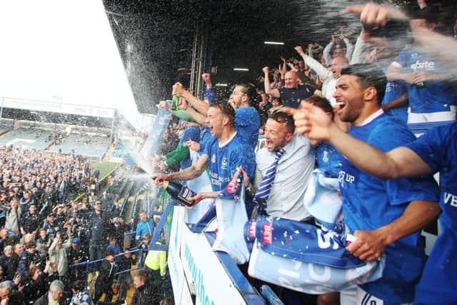 The Pompey players celebrate winning the League Two title on the final day of the 2016-17 season following their 6-1 win against Cheltenham Picture: Joe Pepler