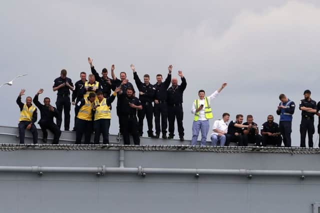 The crew of HMS Queen Elizabeth wave from the deck on the Firth of Forth after leaving the Rosyth dockyard near Edinburgh to begin sea worthiness trials  Photo: Andrew Milligan/PA Wire