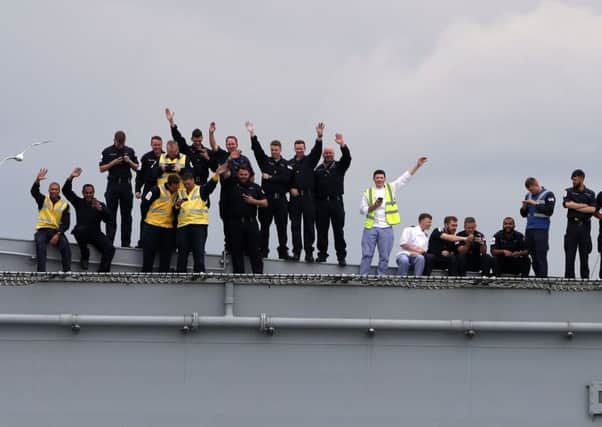 The crew of HMS Queen Elizabeth wave from the deck on the Firth of Forth after leaving the Rosyth dockyard near Edinburgh to begin sea worthiness trials  Photo: Andrew Milligan/PA Wire