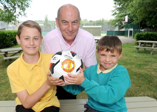 Headteacher Howard Payne with (left) Lenny Horrell, 10, Ryan Hooper, seven, and the signed ball.   Picture: Sarah Standing (170829-4028)
