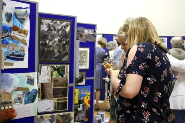 Guests looking at 15-year-old Lottie Fielder's work